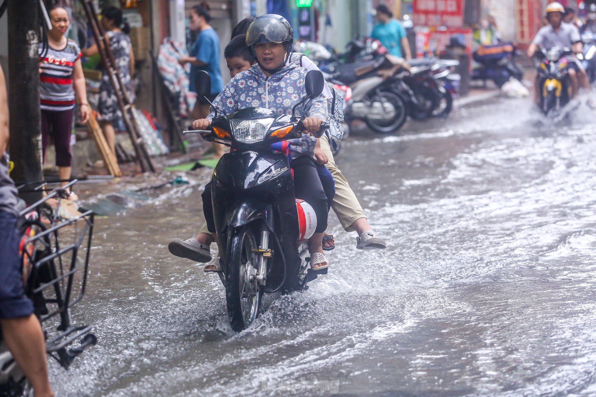 Người dân bì bõm về nhà trên những con phố ngập nước ở Hà Nội-9