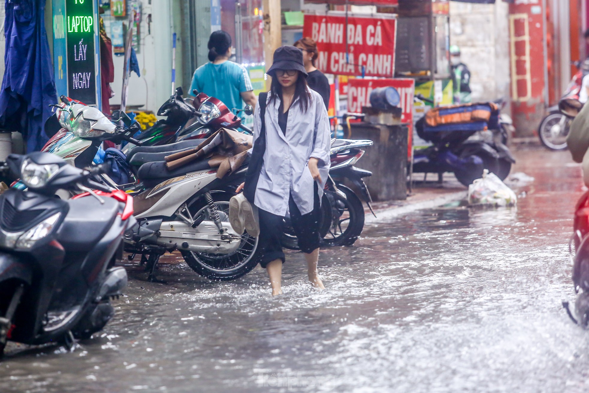 Người dân bì bõm về nhà trên những con phố ngập nước ở Hà Nội-13