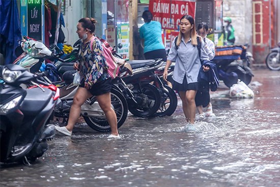 Người dân bì bõm về nhà trên những con phố ngập nước ở Hà Nội