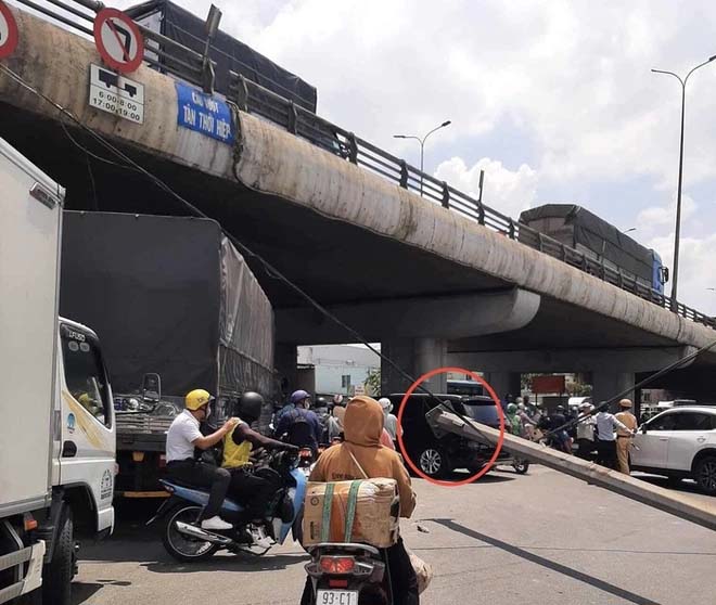 TPHCM: Trụ đèn khủng trên cầu đổ xuống đường, đè trúng một phụ nữ đi xe máy-1
