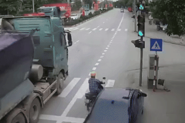 Clip: Ô tô vượt ẩu hất văng người đi xe máy vào đầu xe tải