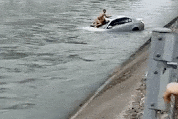 Người dân ôm phao giải cứu tài xế kẹt trong ô tô mất lái rơi xuống sông chảy xiết