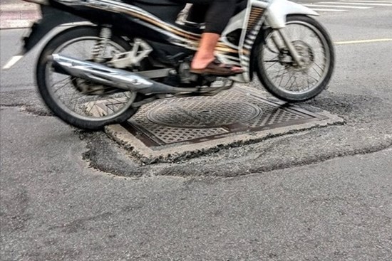 Lý do không nên lái xe máy qua nắp cống khi trời mưa