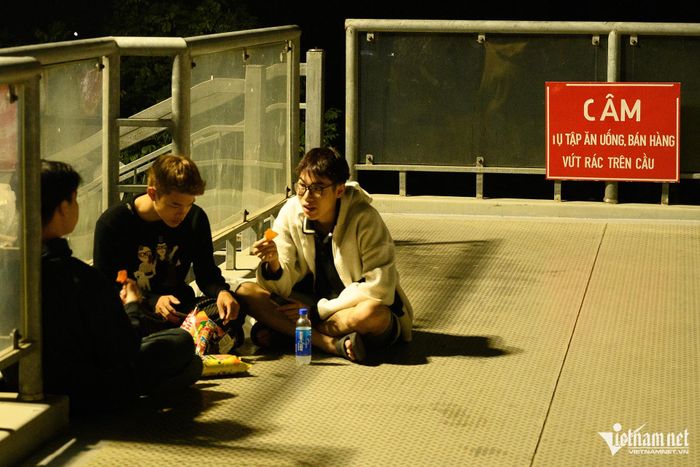 Giới trẻ tụ tập trên cầu vượt bộ hành ăn uống, đàn hát và xả rác-2