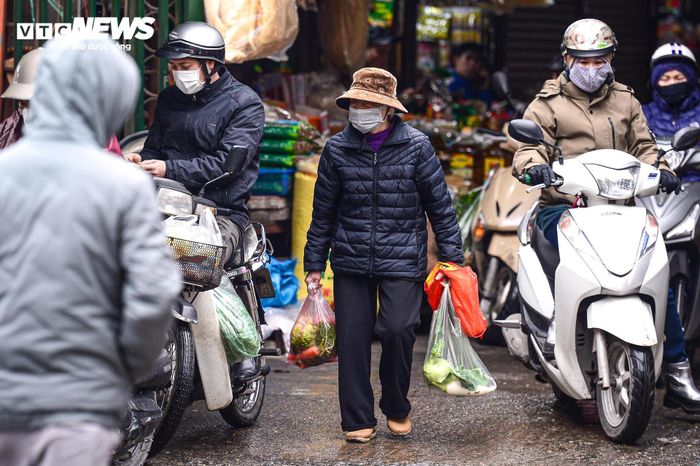 Người lao động ở Hà Nội trùm áo mưa, run rẩy mưu sinh trong giá rét 12°C-2